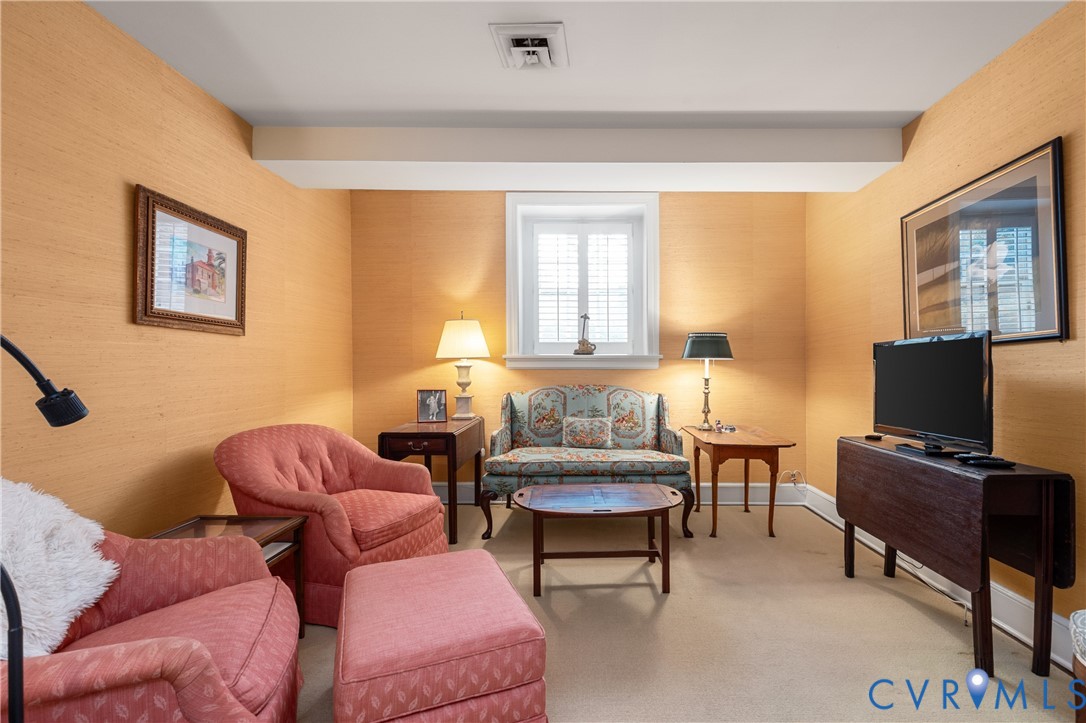 Textured wall coverings, window with integrated shutters, and neutral carpeting