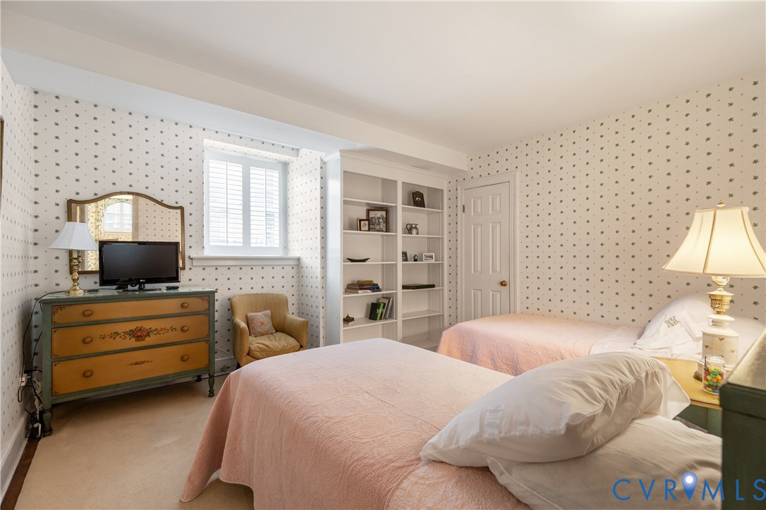 Built-in shelving unit with multiple tiers and single-pane window featuring interior plantation shutters