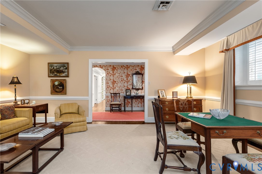 Interior space featuring crown molding, chair rail trim, and window shutters