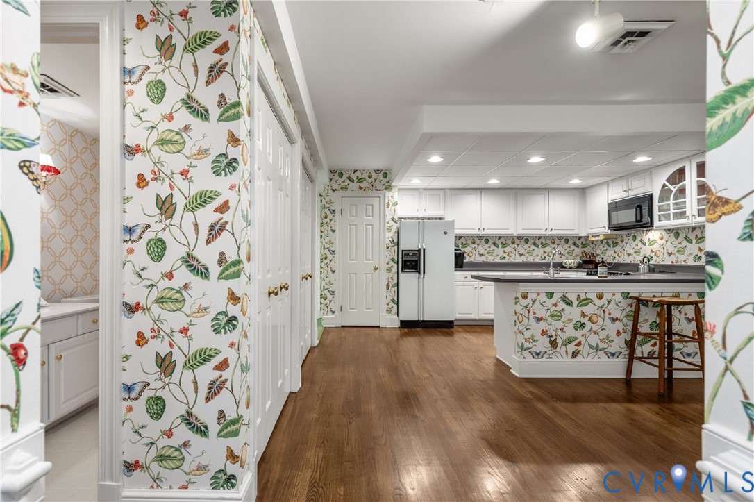 Kitchen featuring wood-finish flooring, white cabinetry, a peninsula counter, and recessed lighting