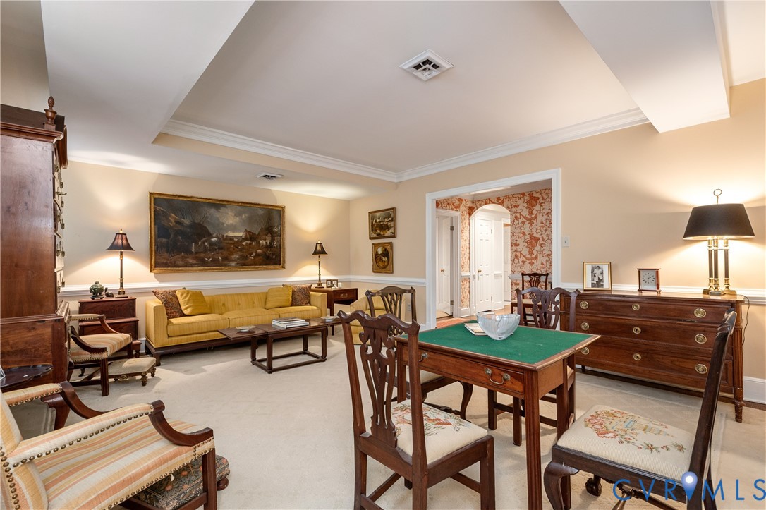 Elegant recreation room showcasing coffered ceiling details, wood-finish flooring, and a green felt billiards table