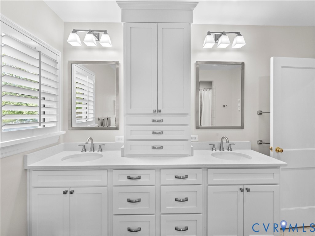 Dual vanity with white cabinetry and integrated sinks