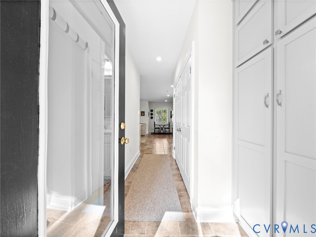 Recessed lighting, tile flooring, white shaker-style cabinetry, and solid panel interior doors