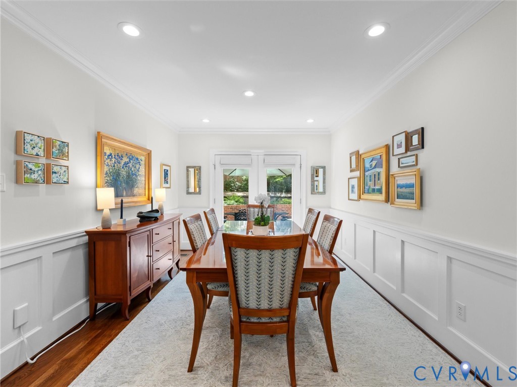 Recessed lighting, crown molding, wood-finish flooring, wainscoting, and a glass-paneled door