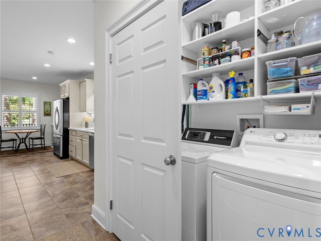 Laundry area featuring built-in shelving, a full-size washer, and a full-size dryer