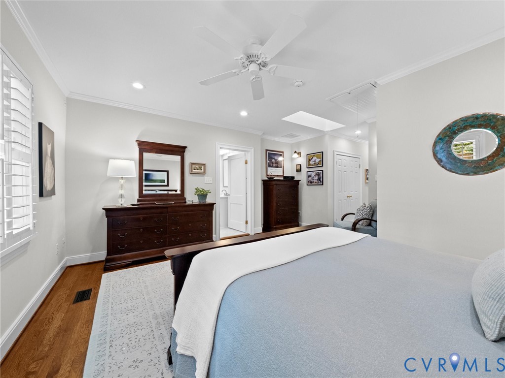 Hardwood flooring, recessed lighting, ceiling fan, crown molding, and window shutters