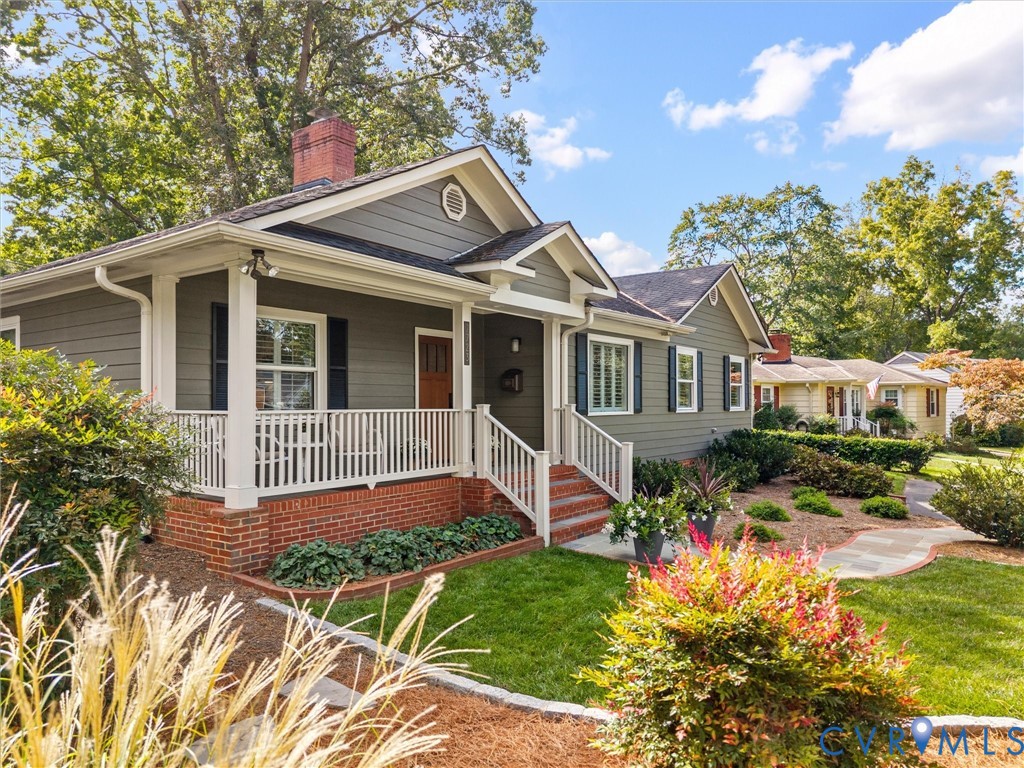 Gable-roof residence featuring horizontal siding, a covered front porch with white railings, and a brick foundation