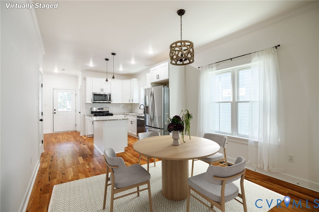 Kitchen featuring white shaker-style cabinetry, stone countertops, stainless steel appliances, wood-finish flooring, and a decorative drum pendant light