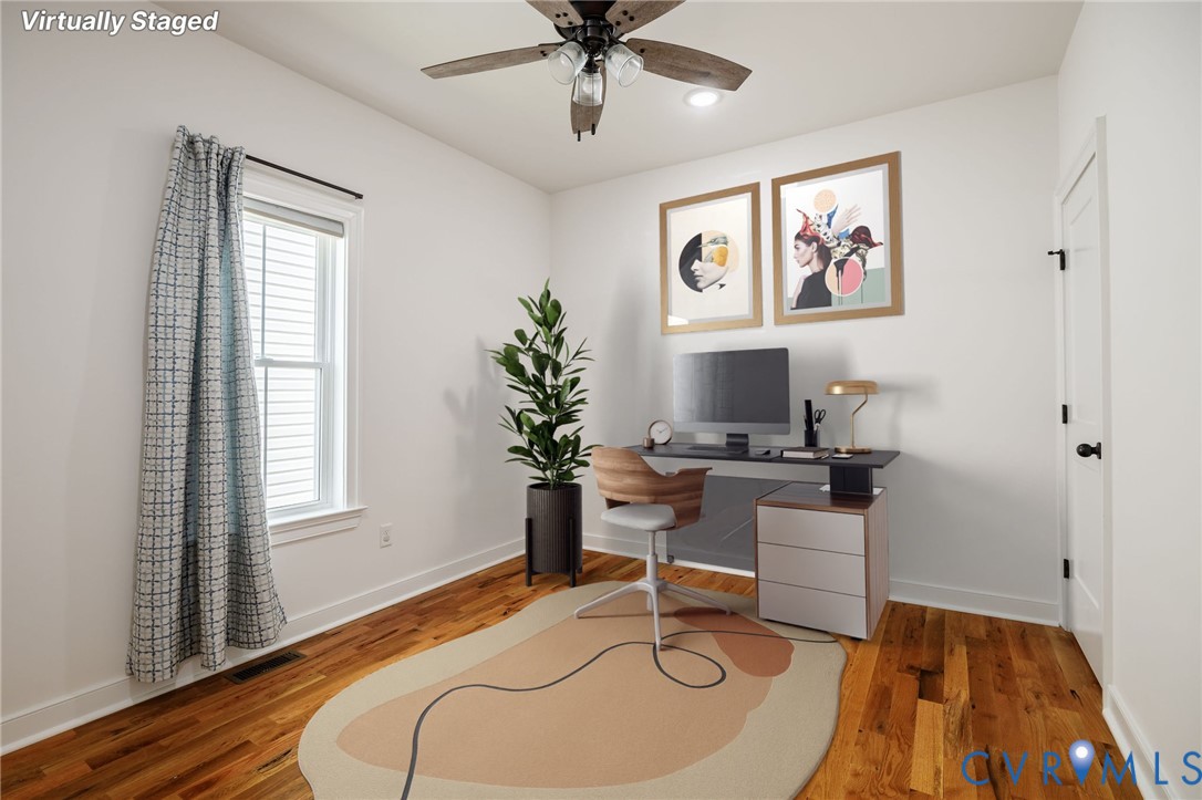 Room featuring wood-finish flooring, a multi-blade ceiling fan with integrated lighting, and a window with white trim