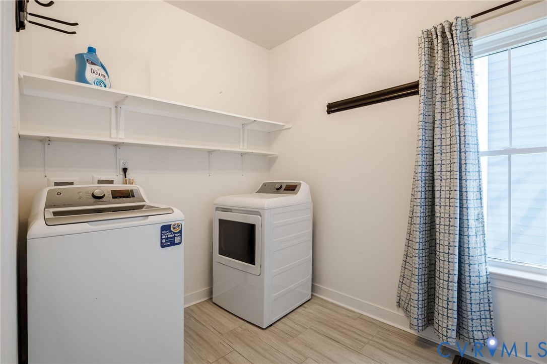 Utility area featuring wood-finish flooring, white shelving, and a double-hung window