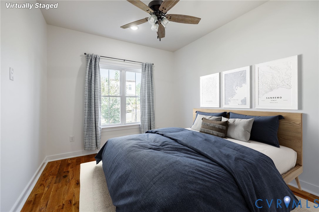 Wood-finish flooring, multi-pane window with white trim, and ceiling fan with integrated lighting