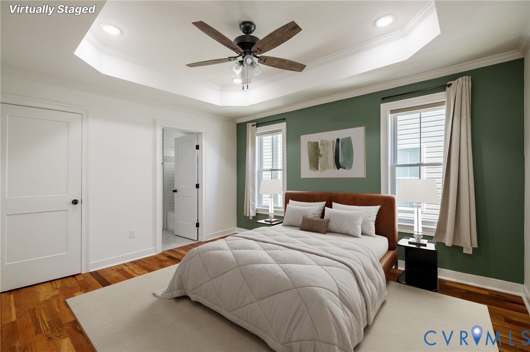 Tray ceiling with recessed lighting, wood-finish flooring, and a five-blade ceiling fan with integrated light fixture