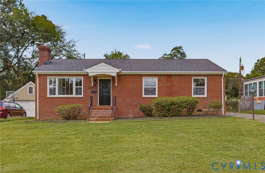 Brick exterior featuring a gabled roof and white window trim
