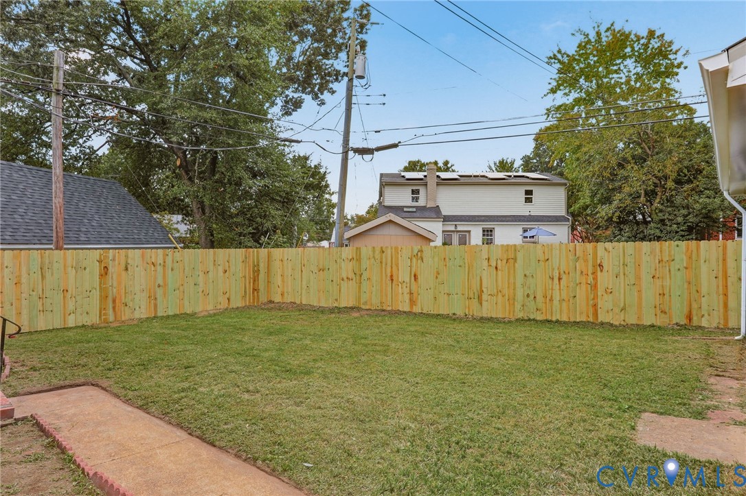 Expansive grass lawn with new wood privacy fencing