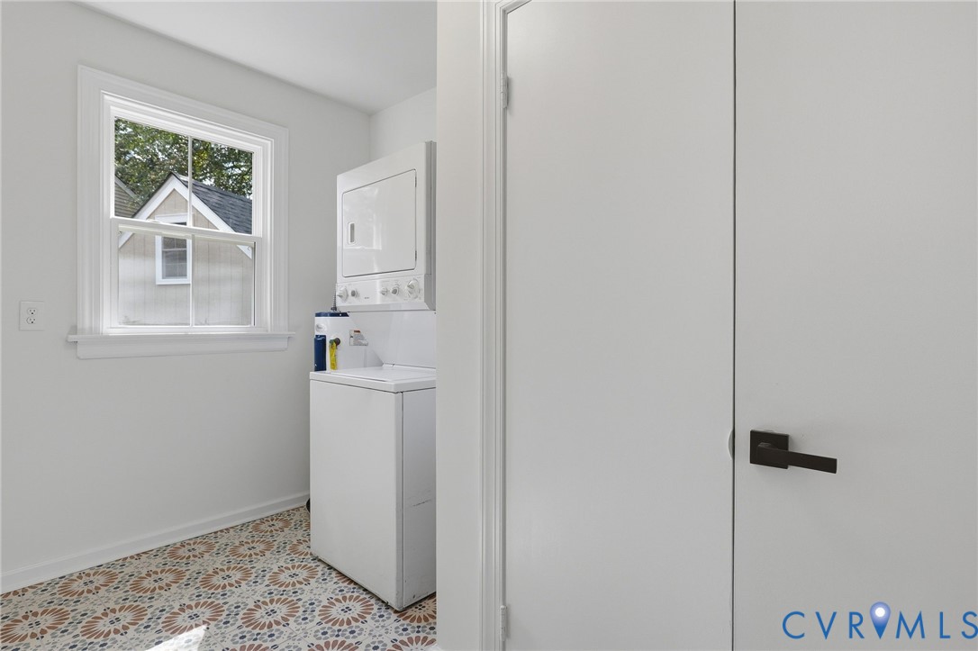 White interior walls, patterned floor tiles, white window trim, and white bi-fold doors with matte black hardware