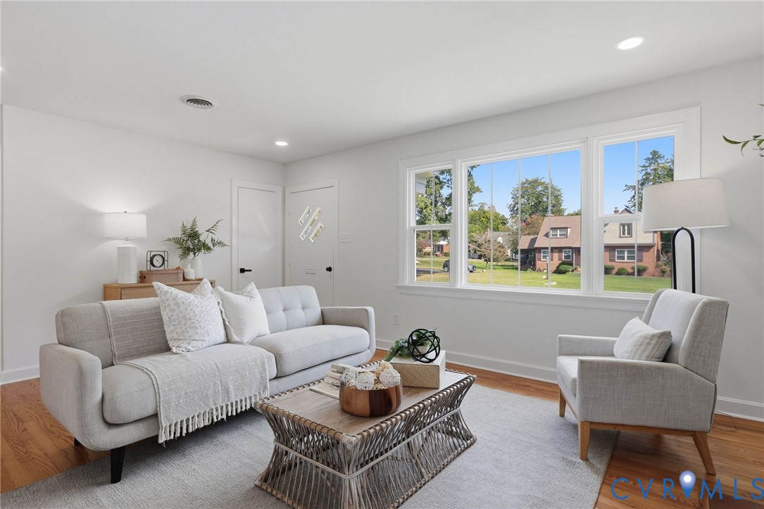White walls with recessed lighting, wood-finish flooring, and a multi-pane window