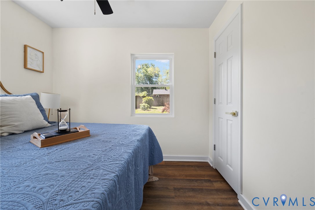 Smooth white walls, rich wood-finish flooring, and a white paneled door with brass hardware