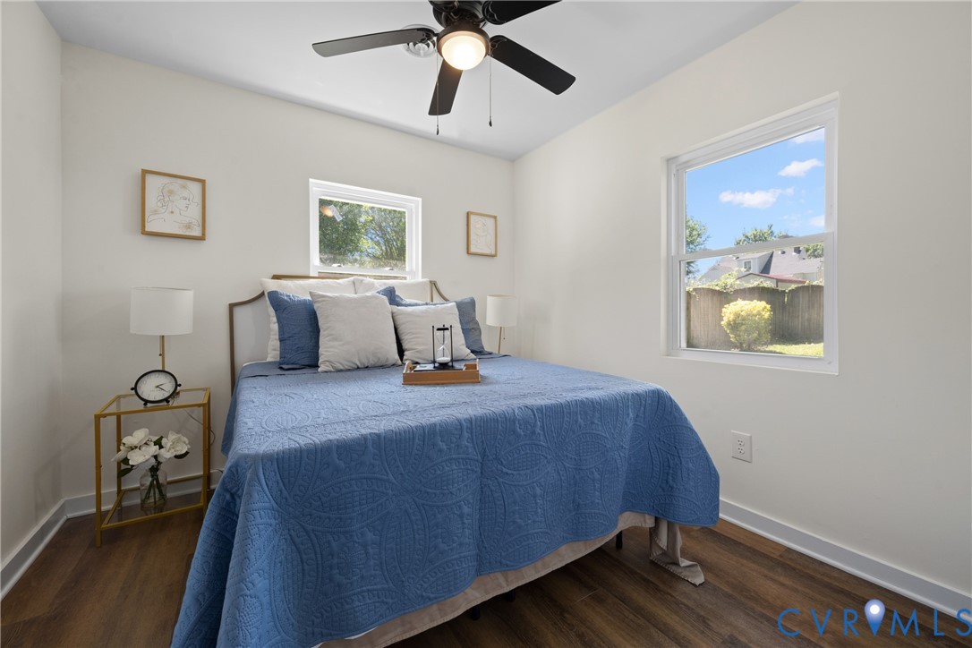 Wood-finish flooring, white walls, and a ceiling fan with integrated lighting