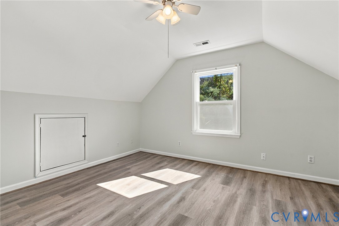 Vaulted ceilings, wood-finish flooring, a single-hung window, and built-in access panel