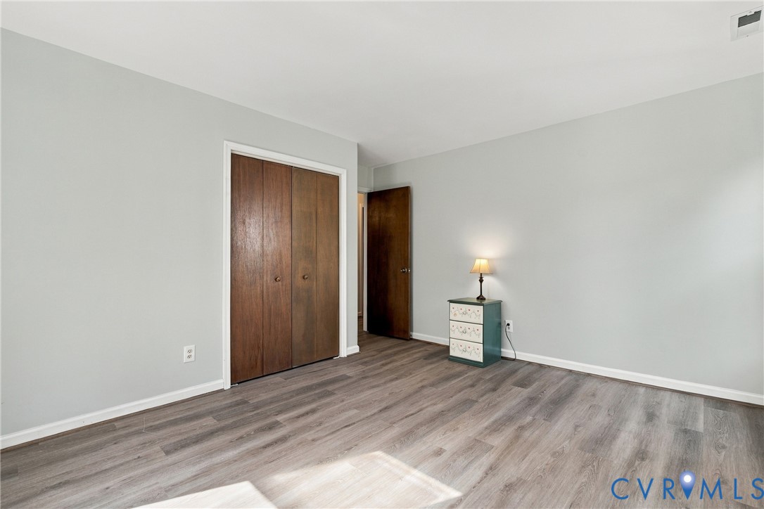 Neutral-toned interior featuring wood-finish flooring and floor-to-ceiling bi-fold closet doors