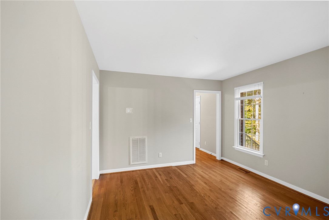 Neutral wall finishes, wood-finish flooring, and a multi-pane window
