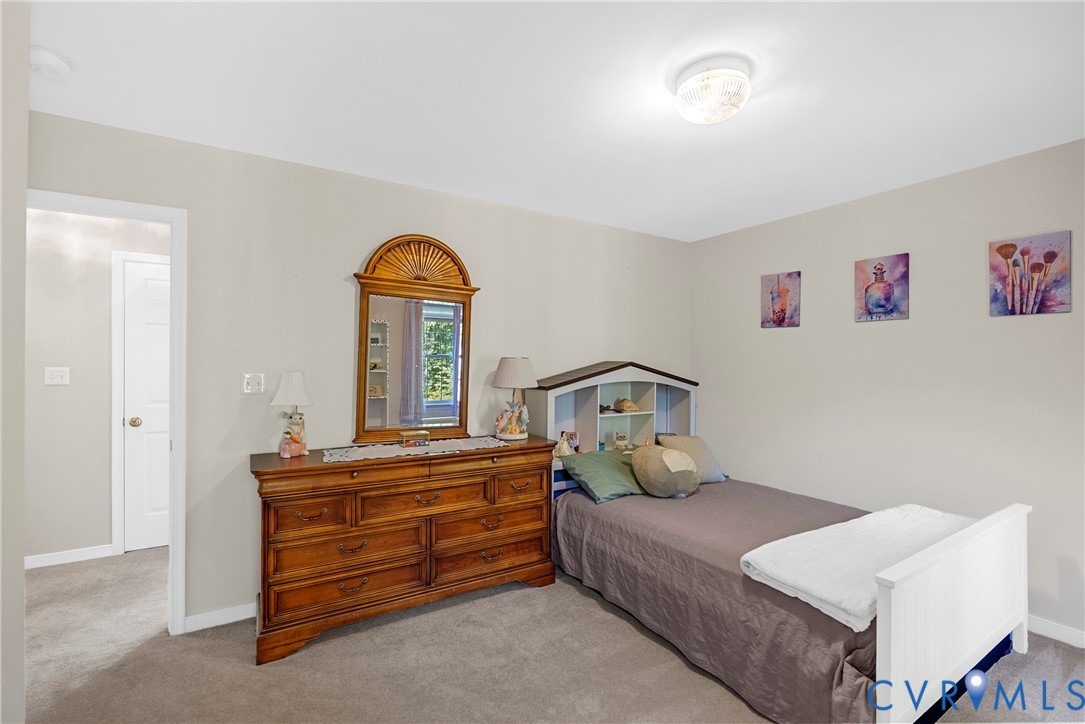 Neutral-toned interior space featuring carpeting, smooth wall finish, and a ceiling-mounted light fixture