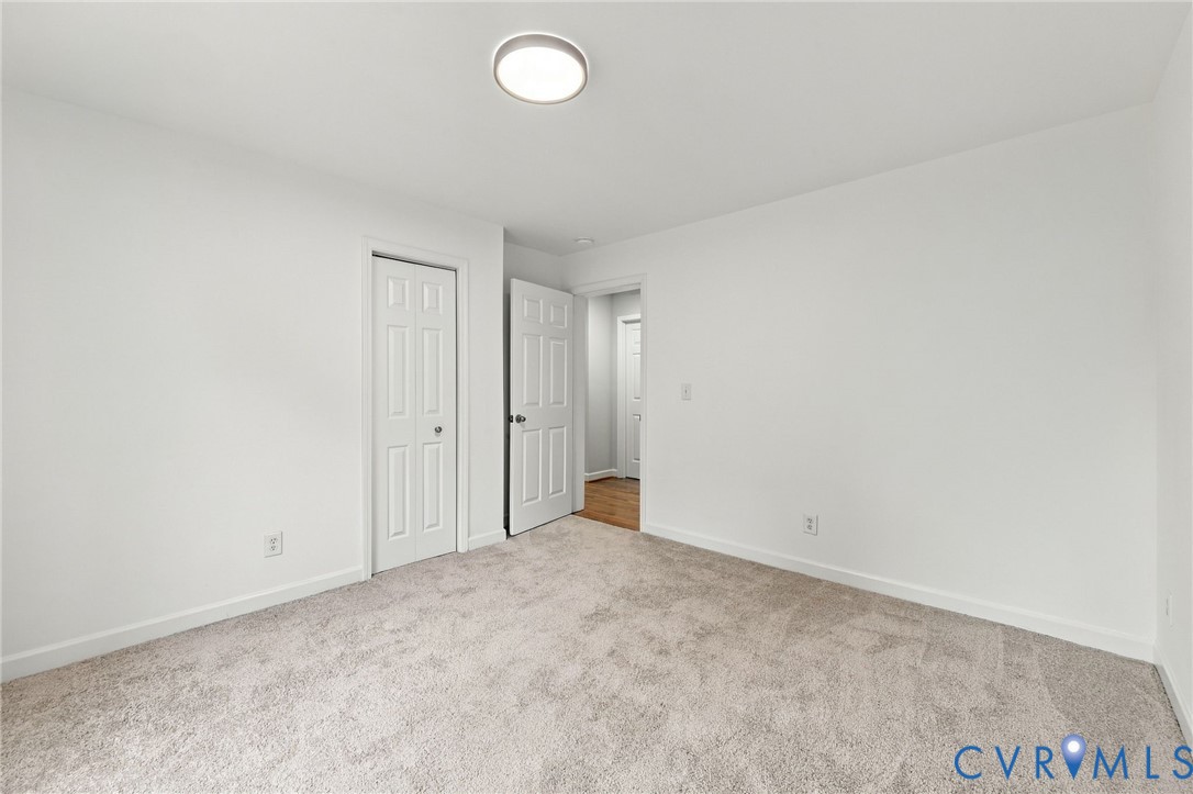 Neutral-toned carpeting, flush-mount LED ceiling lighting, and solid-core six-panel interior doors