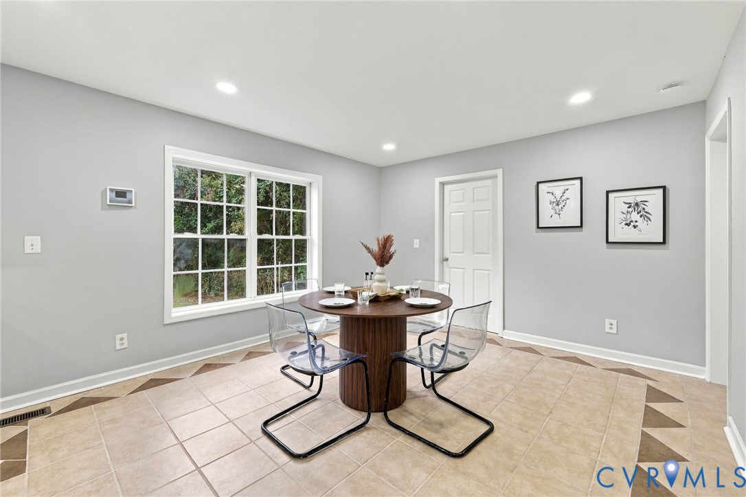 Neutral-toned walls featuring recessed lighting, a multi-pane window, and decorative tile flooring with patterned geometric borders