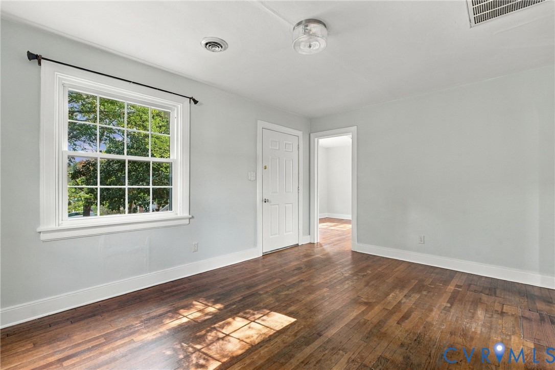 Hardwood flooring, painted walls, white trim, white paneled door, and a white grid window Hardwood flooring, painted walls, white trim, white paneled door, and a white grid window