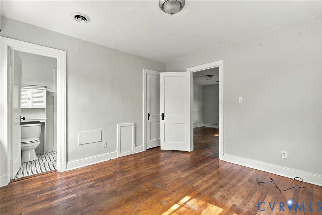 Hardwood-finish flooring, white trim, light-toned walls, and a ceiling-mounted light fixture Hardwood-finish flooring, white trim, light-toned walls, and a ceiling-mounted light fixture