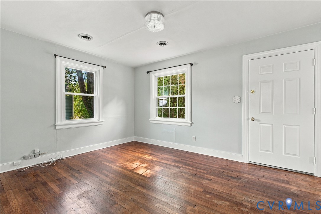 Hardwood flooring, two windows, recessed lighting, and a paneled door Hardwood flooring, two windows, recessed lighting, and a paneled door