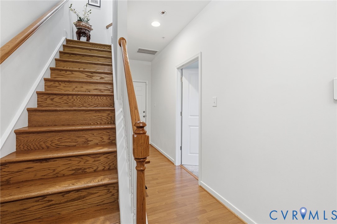 Wood-finish flooring throughout, complemented by a staircase with wood treads and a coordinating wood handrail