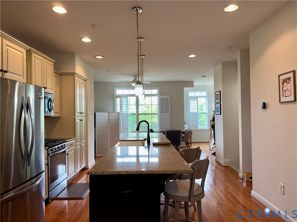 Chef's kitchen showcasing stainless steel appliances, custom cabinetry with soft-close doors, and a large center island with seating