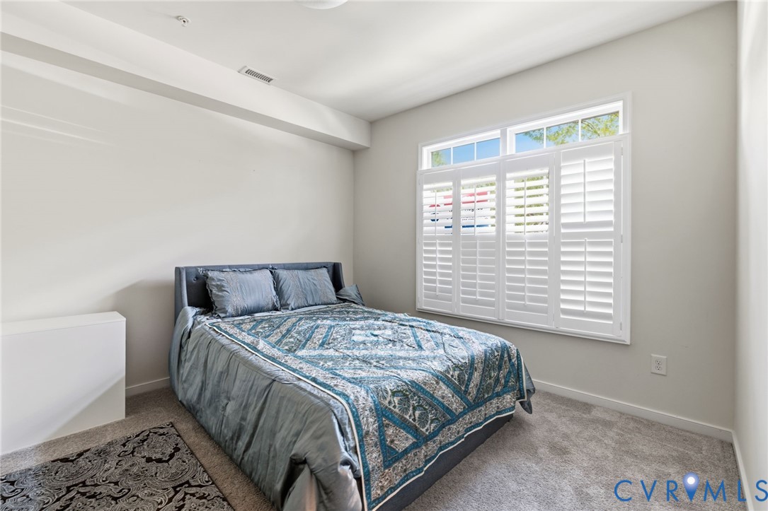 Carpeted flooring, white plantation shutters, transom windows, and recessed lighting
