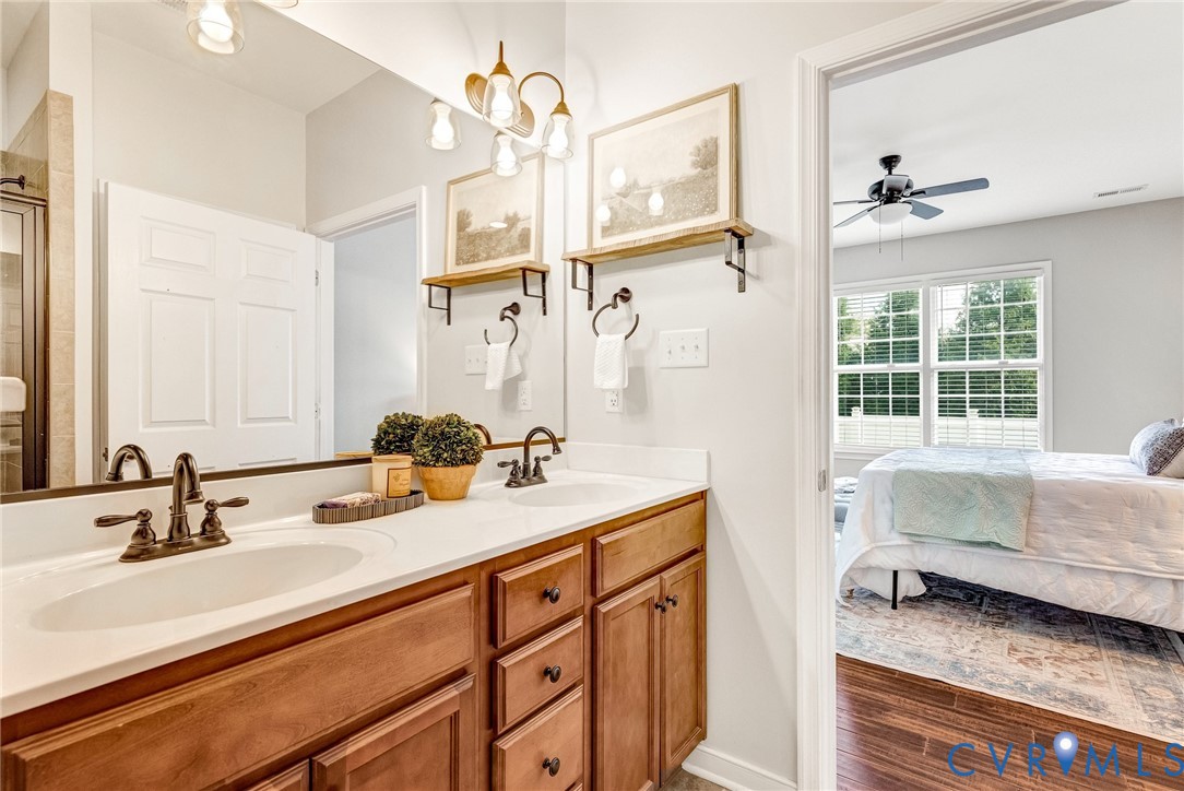 Dual vanity with bronze-finish fixtures and light wood-finish cabinetry