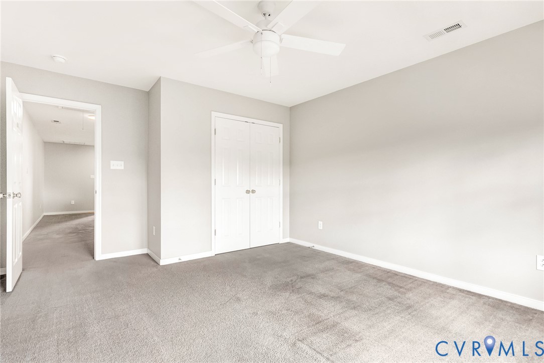 Neutral wall tones, gray carpeting, dual-door closet, ceiling fan, and recessed lighting