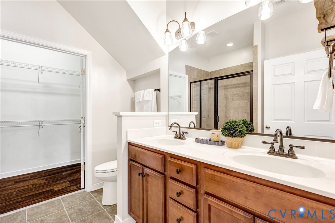 Dual sink vanity with wood-finish cabinetry and white countertop