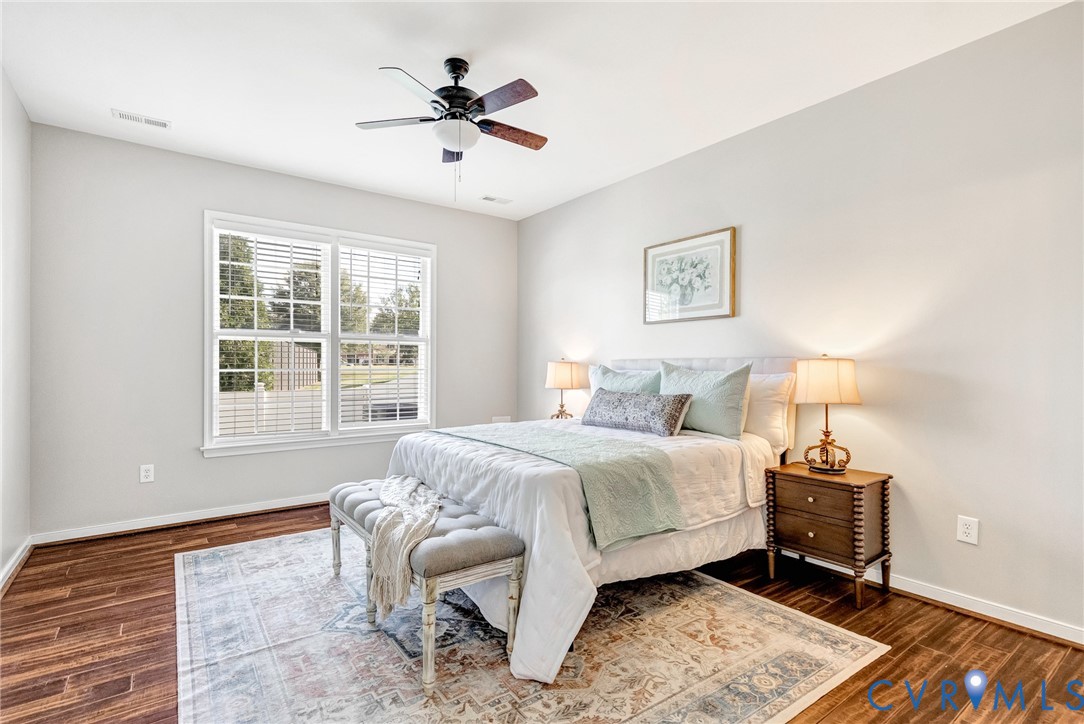 Wood-finish flooring, white walls, and a ceiling fan with integrated lighting