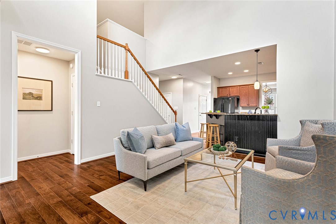 Expansive vaulted ceiling with a two-story staircase featuring wood handrails and white balusters