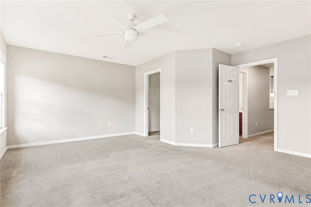 Carpeted room with a ceiling fan, light gray walls, white trim, and white paneled doors