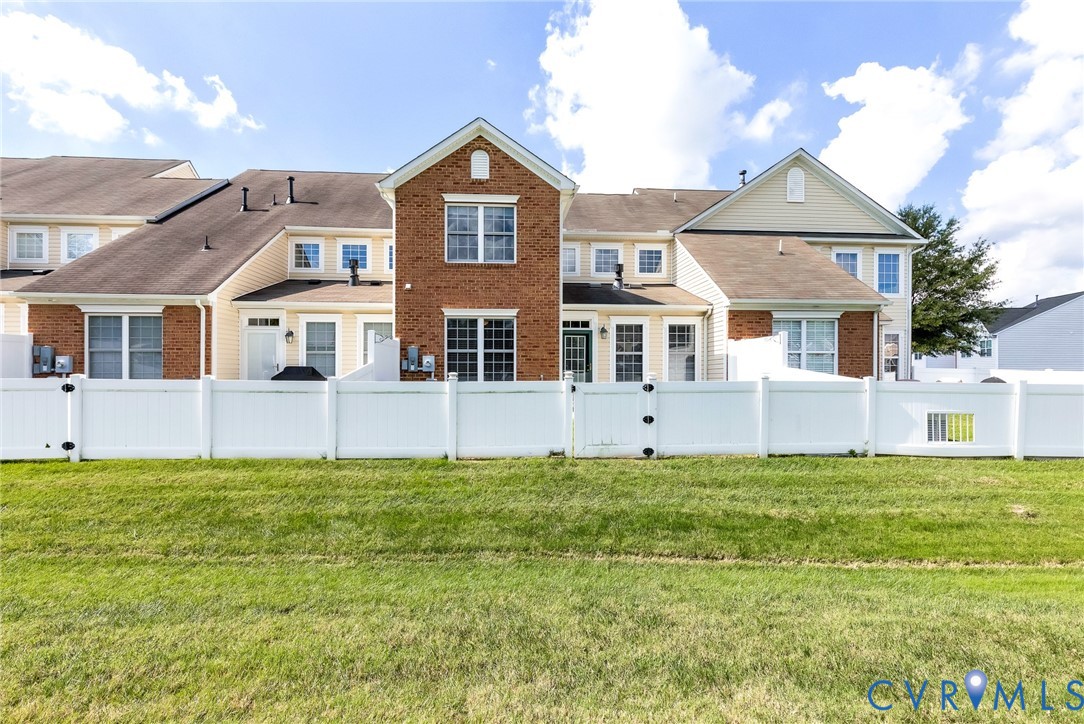 Expansive green space featuring a white privacy fence