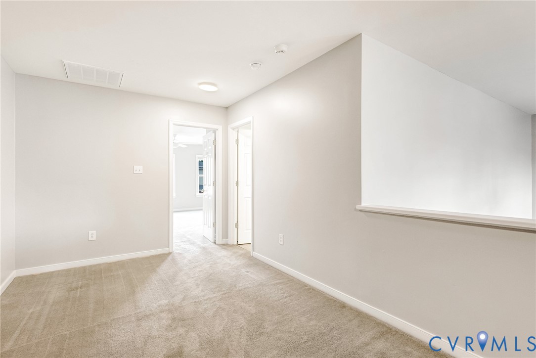 Neutral-toned walls, carpeted flooring, white trim, recessed lighting, and a white interior door frame