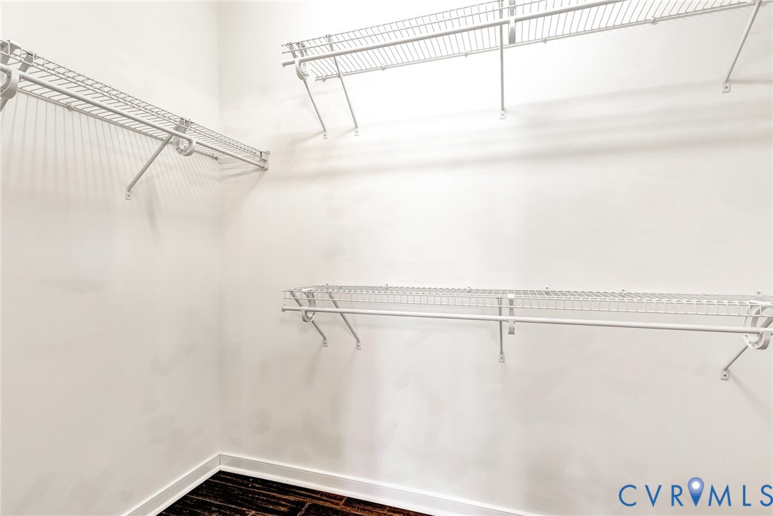 Integrated wire shelving system with multiple storage levels and dark wood-finish flooring