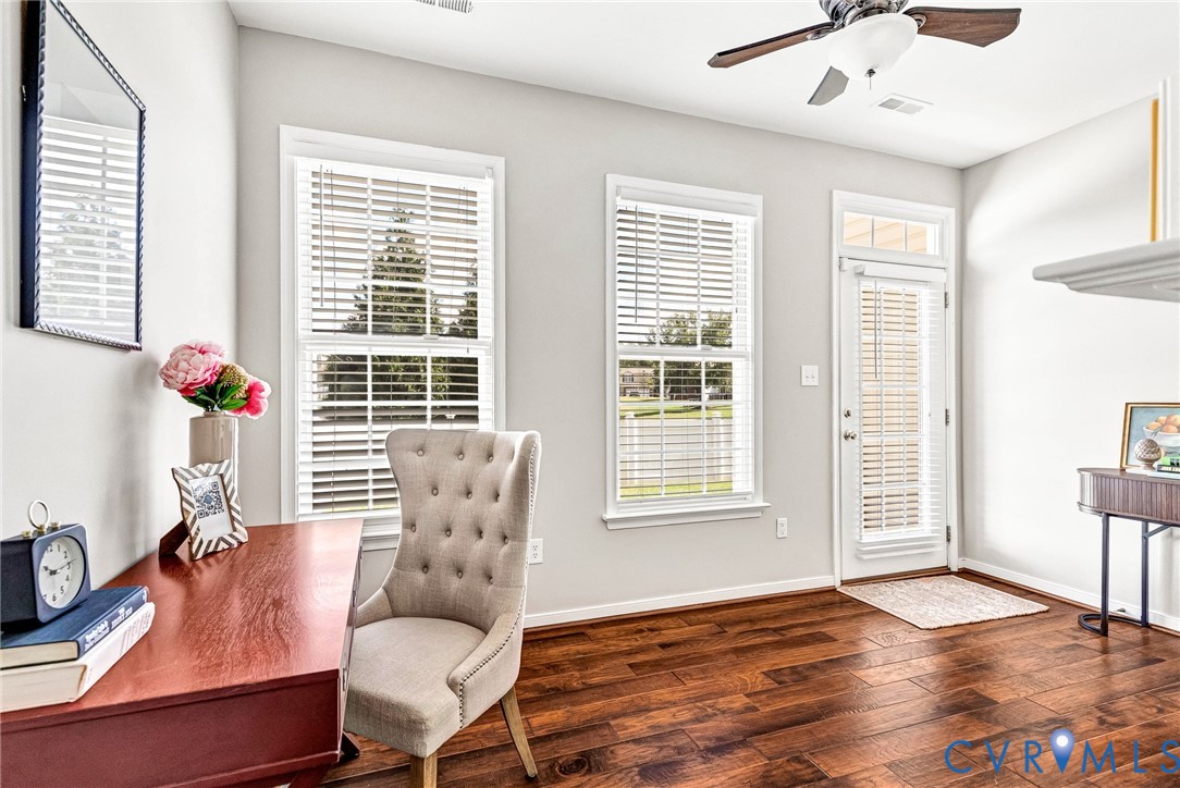 Wood-finish flooring throughout, two windows with blinds, and a white door with transom window