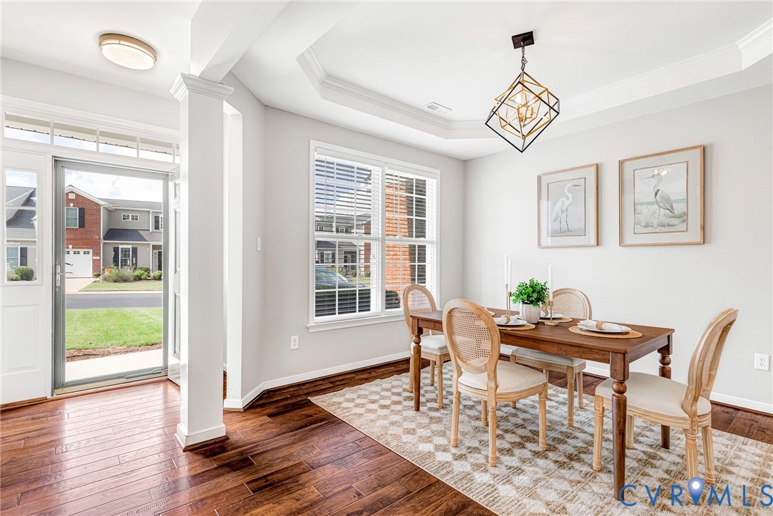 Hardwood-finish flooring, recessed lighting, tray ceiling, modern geometric chandelier, and white window blinds Hardwood-finish flooring, recessed lighting, tray ceiling, modern geometric chandelier, and white window blinds