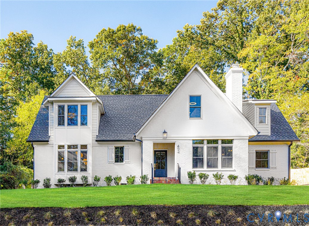 Painted brick exterior featuring a steep roofline, gabled dormers, a side-profile chimney, and multi-pane windows Painted brick exterior featuring a steep roofline, gabled dormers, a side-profile chimney, and multi-pane windows