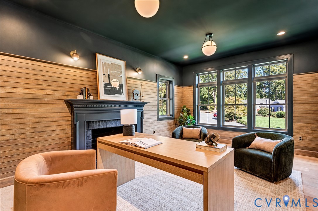 Horizontal wood plank wall paneling, painted fireplace mantle, multi-pane windows, wood-finish flooring, and globe-style lighting fixtures