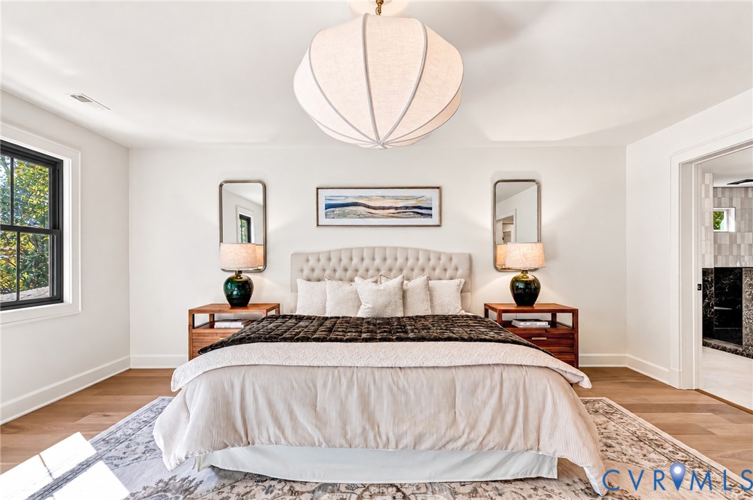 Wood-finish flooring, crisp white walls, and a prominent sculptural pendant light fixture