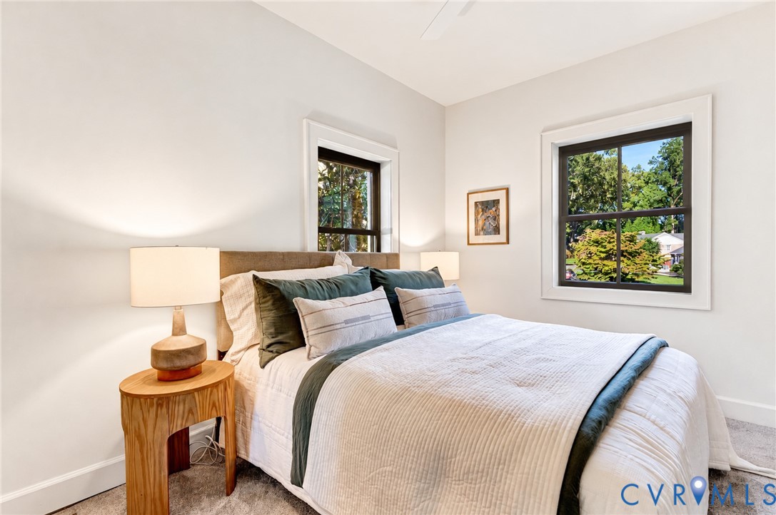 Neutral interior featuring high ceilings, dark-framed windows, and carpeted flooring