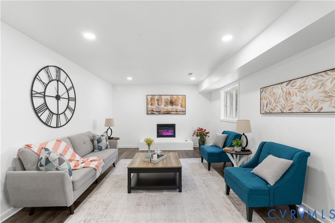 Recessed lighting illuminates the wood-finish flooring and white walls